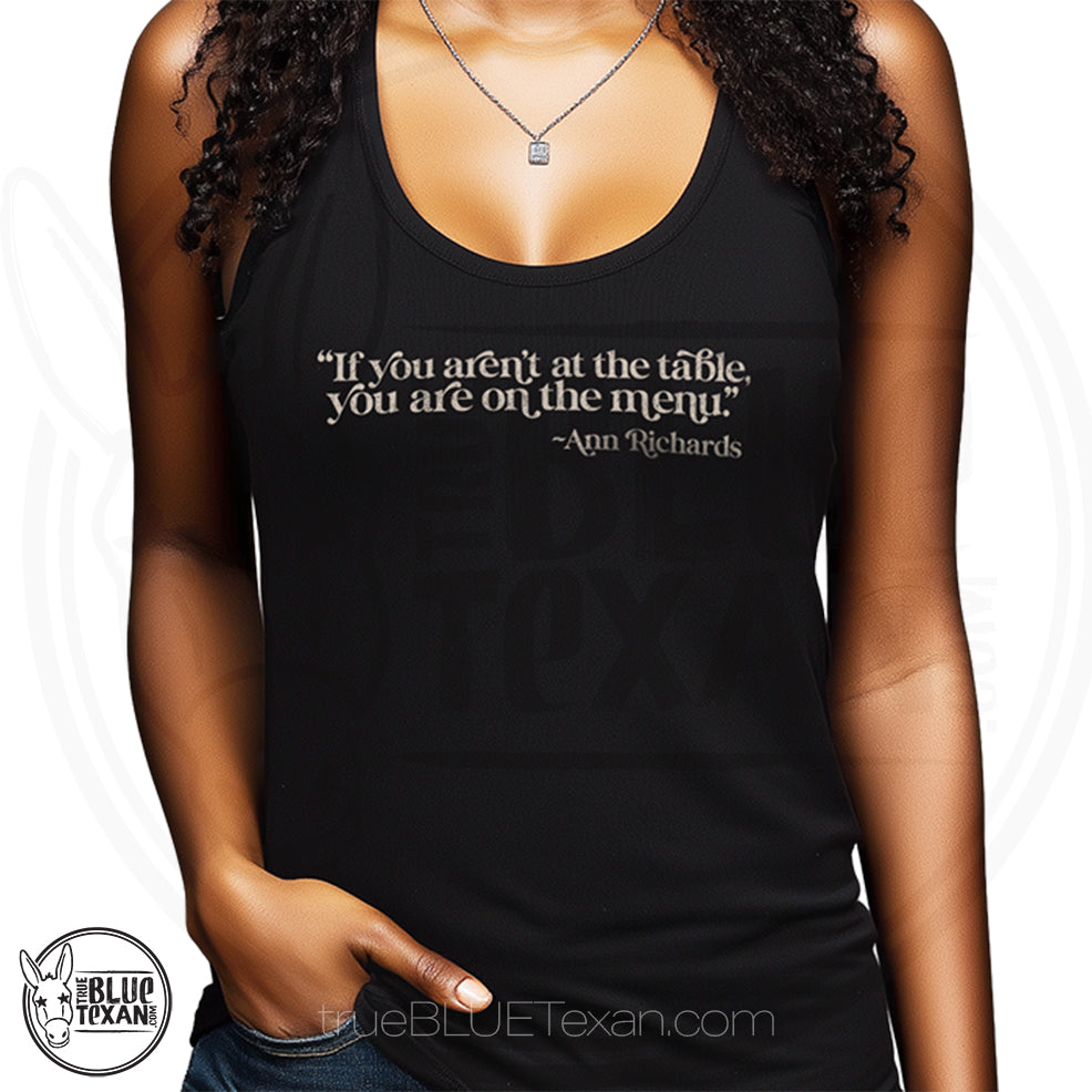 "If you aren't at the table, you are on the menu Ann Richards" quote women's racerback tank top in black