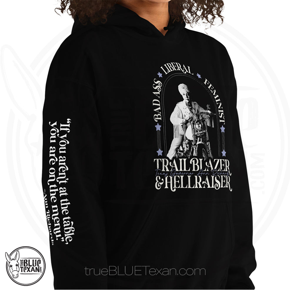 Bad Ass, Liberal, Feminist, Trailblazer, Hellraiser. Texas Governor Ann Richards premium unisex hoodie sweatshirt in black The arm features the quote "If you aren't at the table. you are on the menu."
