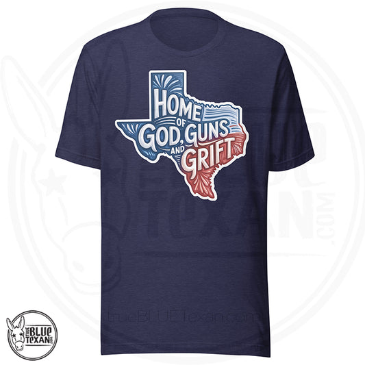 Navy blue t-shirt with Texas-shaped design and text 'Home of God, Guns and Grift' on a white background.